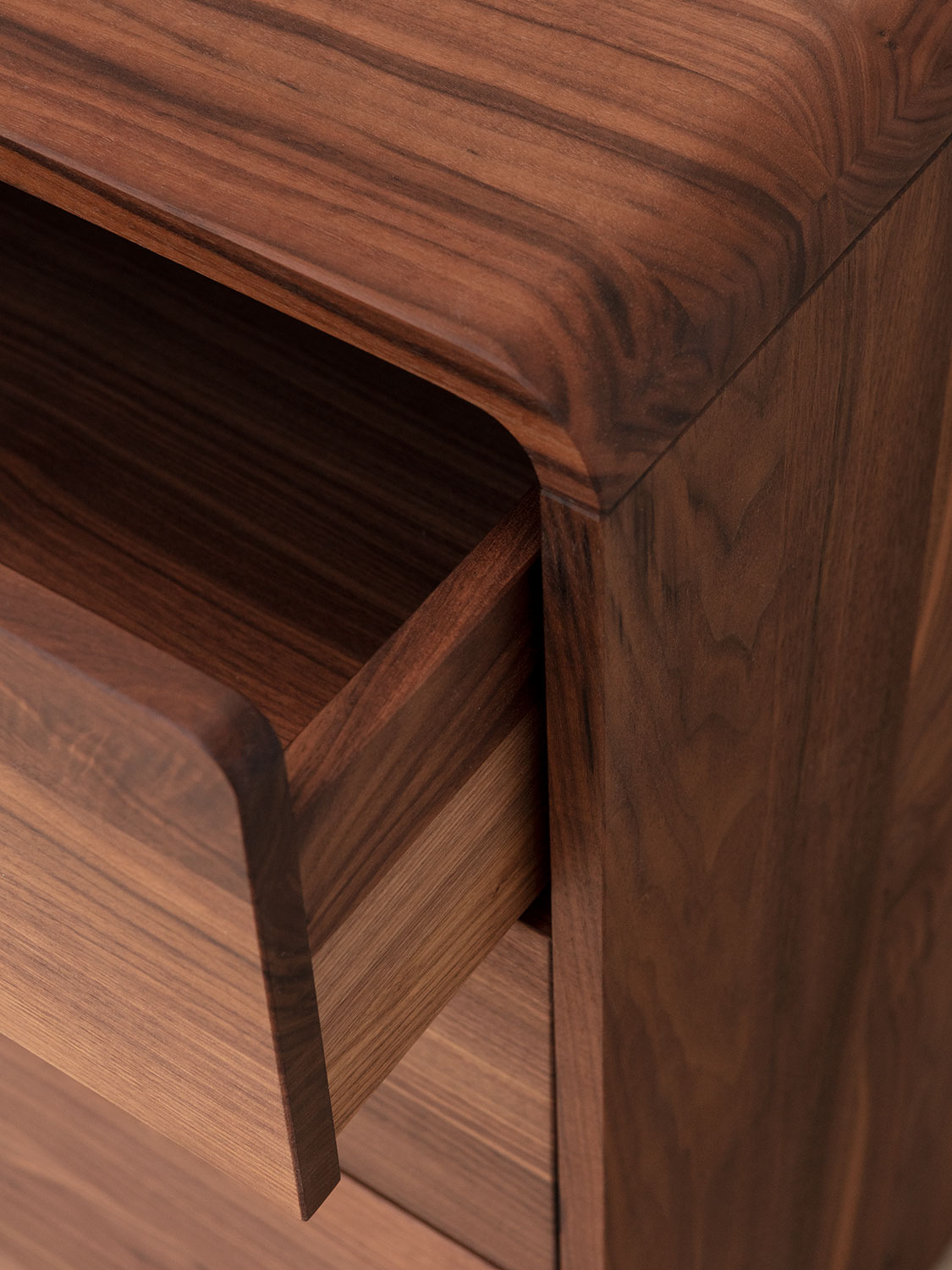 Massivholzkommode aus Nussbaum, Detail der gerundeten Eckverbindung sowie der Schubladeninnenzargen in Nussbaum