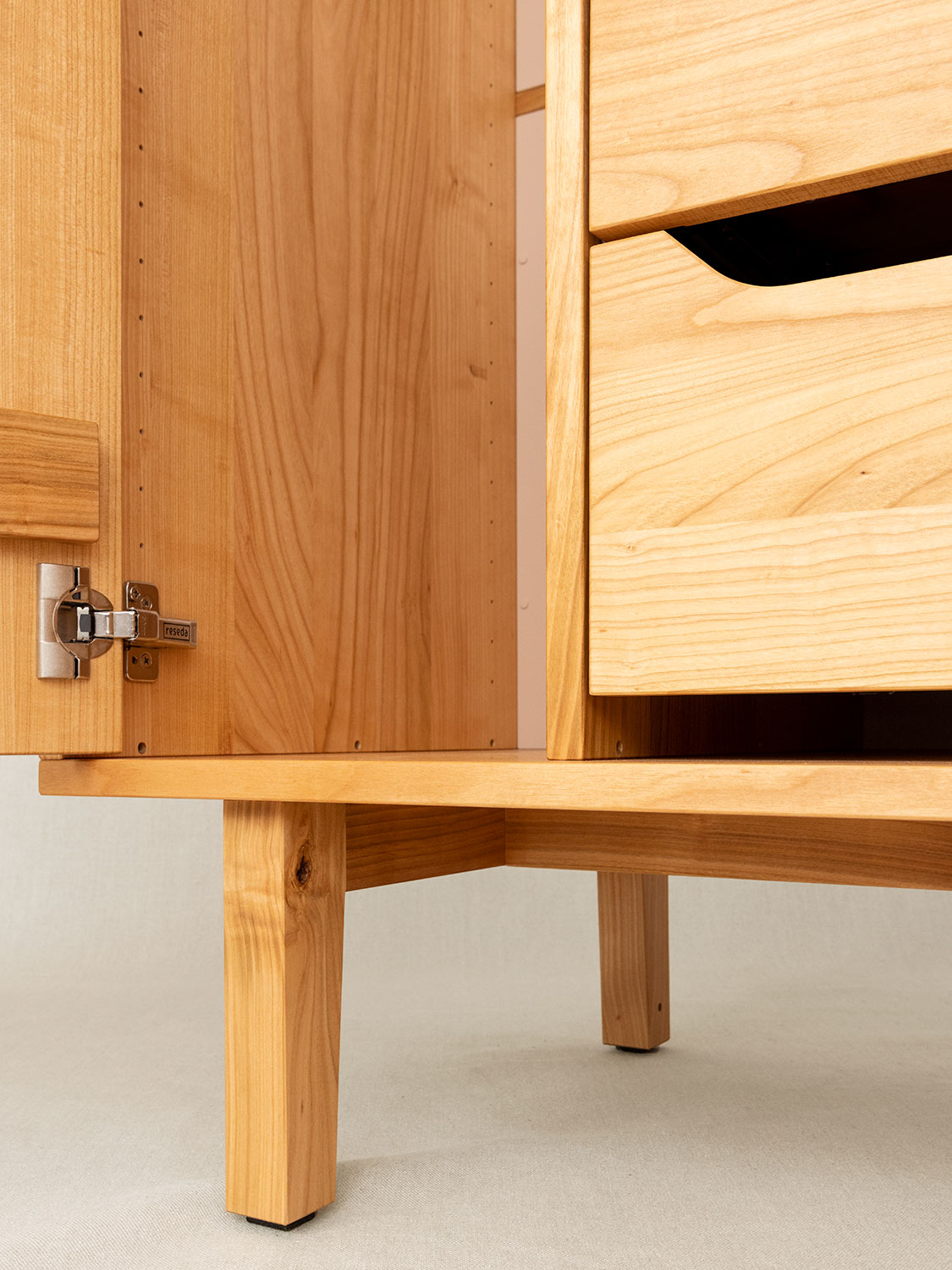 Massivholzschrank auf Füssen in Kirschbaum, Detail Fussunterkonstruktion